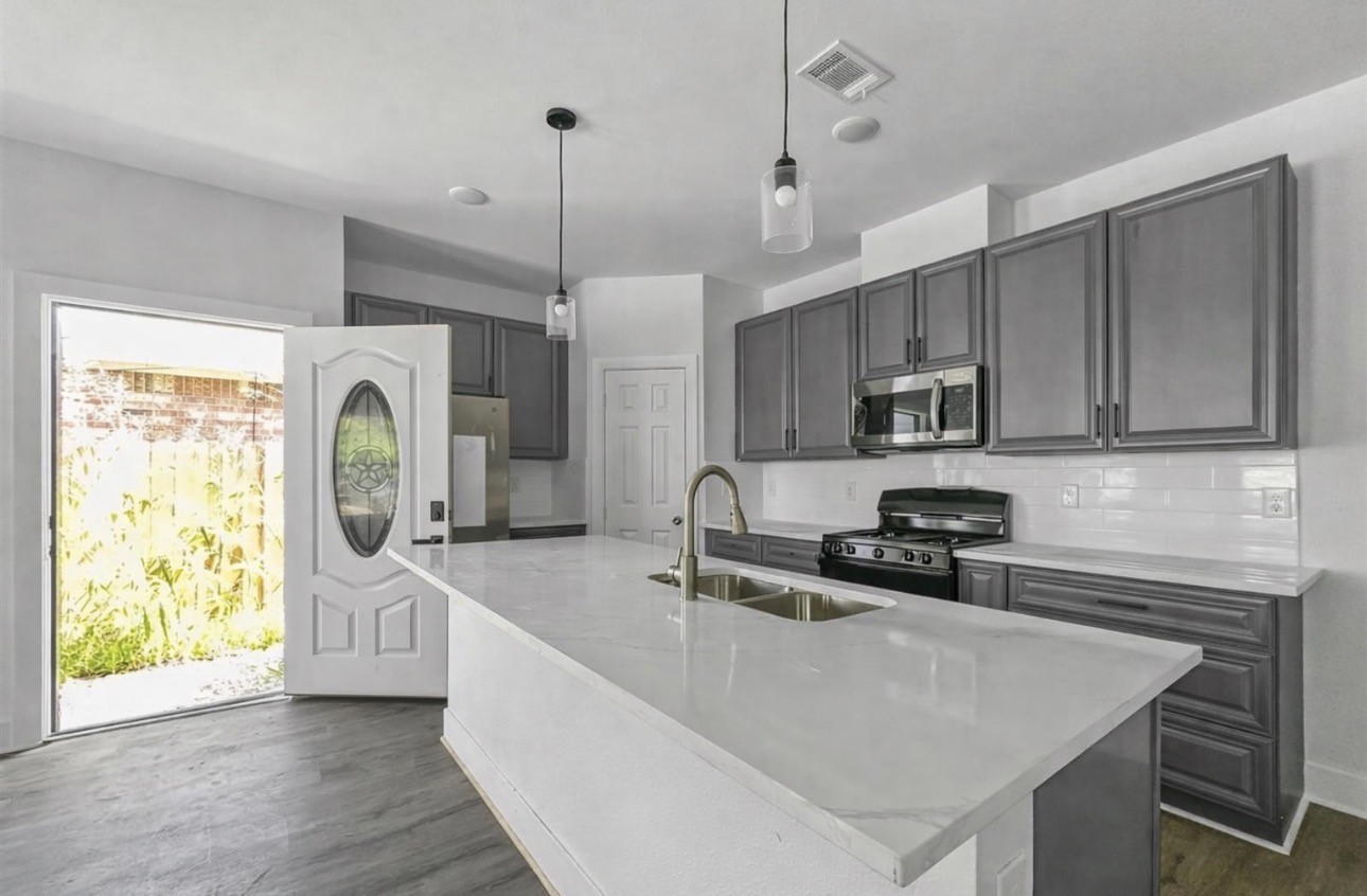 6010 Bobby Burns Street Houston, TX 77028 - Photo 7 of 22 a kitchen with stainless steel appliances granite countertop a sink a stove and a refrigerator