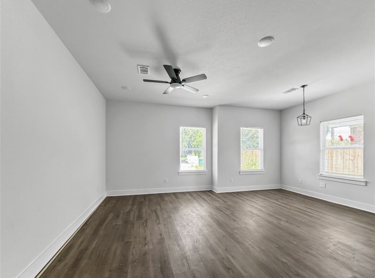 6010 Bobby Burns Street Houston, TX 77028 - Photo 9 of 22 an empty room with wooden floor and windows