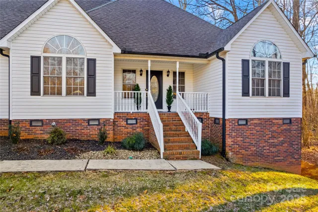a view of a white house with iron fence