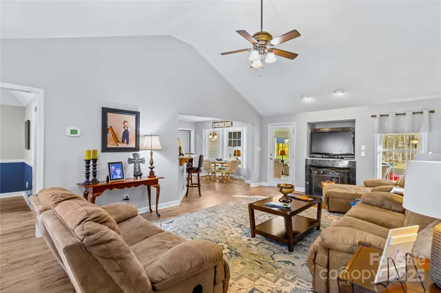 a living room with furniture kitchen view and a chandelier