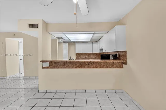 a kitchen with granite countertop white cabinets and white appliances