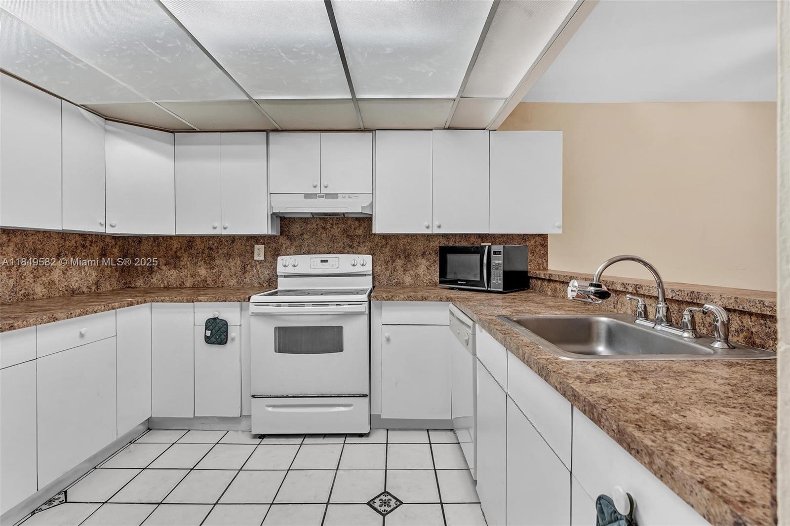 3750 Southwest 60th Terrace, Unit 1 Davie, FL 33314 - Photo 20 of 56 a kitchen with granite countertop a sink stove and cabinets