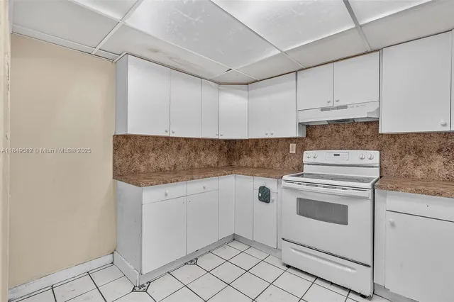 a kitchen with granite countertop white cabinets and white appliances
