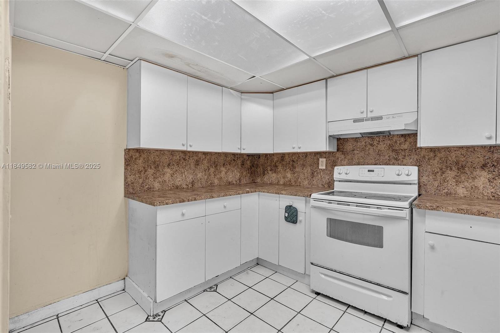 3750 Southwest 60th Terrace, Unit 1 Davie, FL 33314 - Photo 21 of 56 a kitchen with granite countertop white cabinets and white appliances