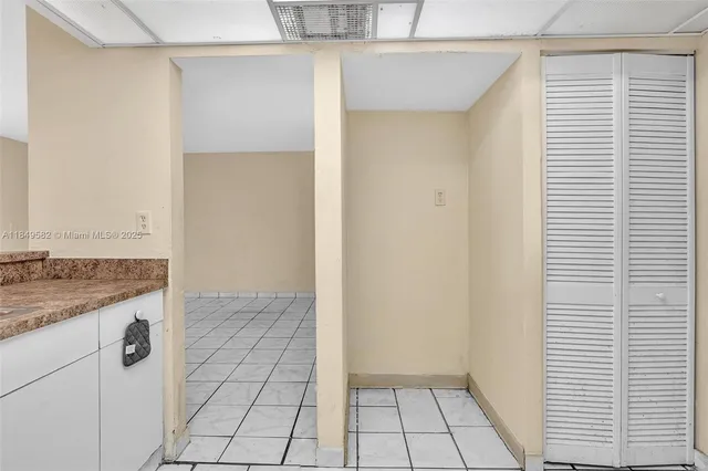 a white toilet sitting next to a white wall