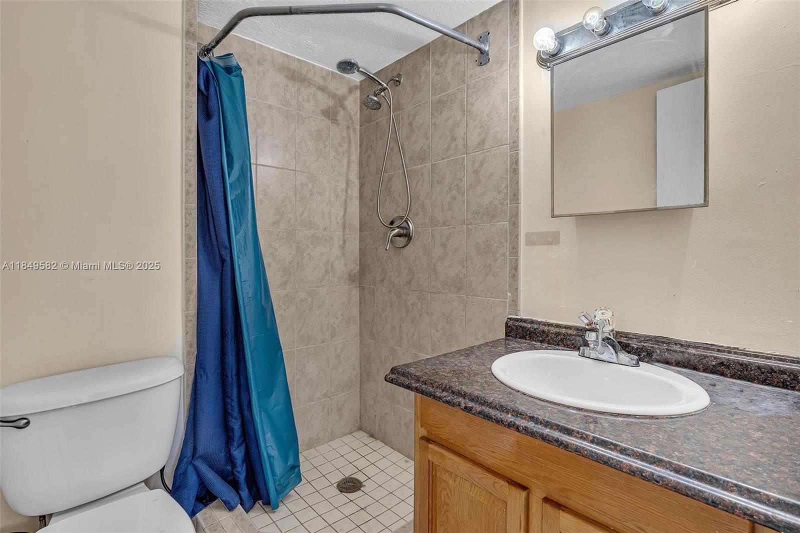 3750 Southwest 60th Terrace, Unit 1 Davie, FL 33314 - Photo 35 of 56 a bathroom with a granite countertop sink toilet and a mirror