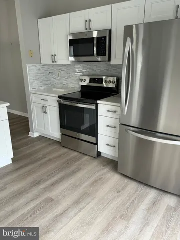 a kitchen with stainless steel appliances kitchen island granite countertop a stove a refrigerator and a microwave