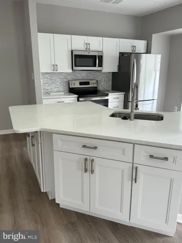 a kitchen with stainless steel appliances white cabinets and a refrigerator