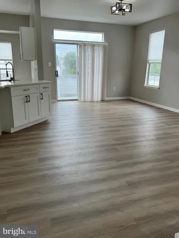 a view of a room with wooden floor and a window