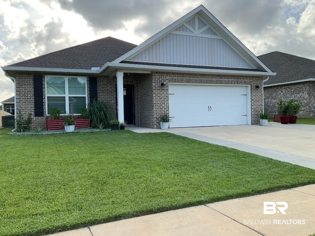 1093 Pheasant Circle Foley, AL 36535 - Photo 1 of 25 Ranch-style home with concrete driveway, brick siding, roof with shingles, and a front yard