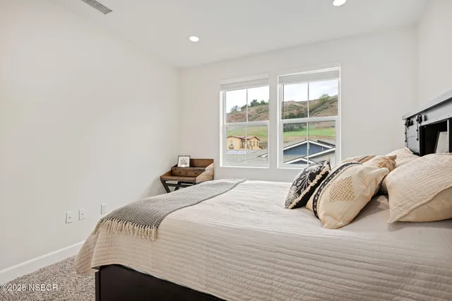 a bedroom with a bed and a large window