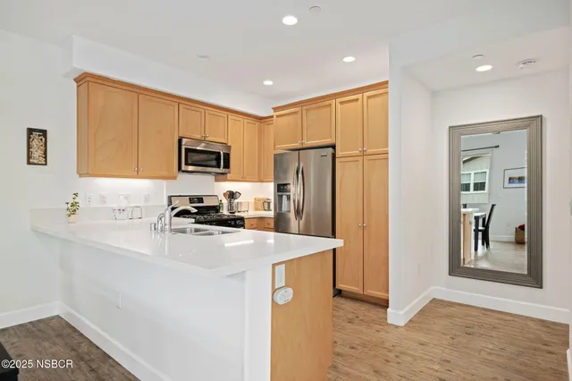 a kitchen with a refrigerator a microwave a sink and cabinets