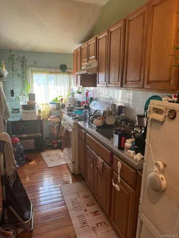 a kitchen with granite countertop a sink dishwasher stove and cabinets