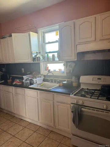 a kitchen with granite countertop white cabinets and white appliances