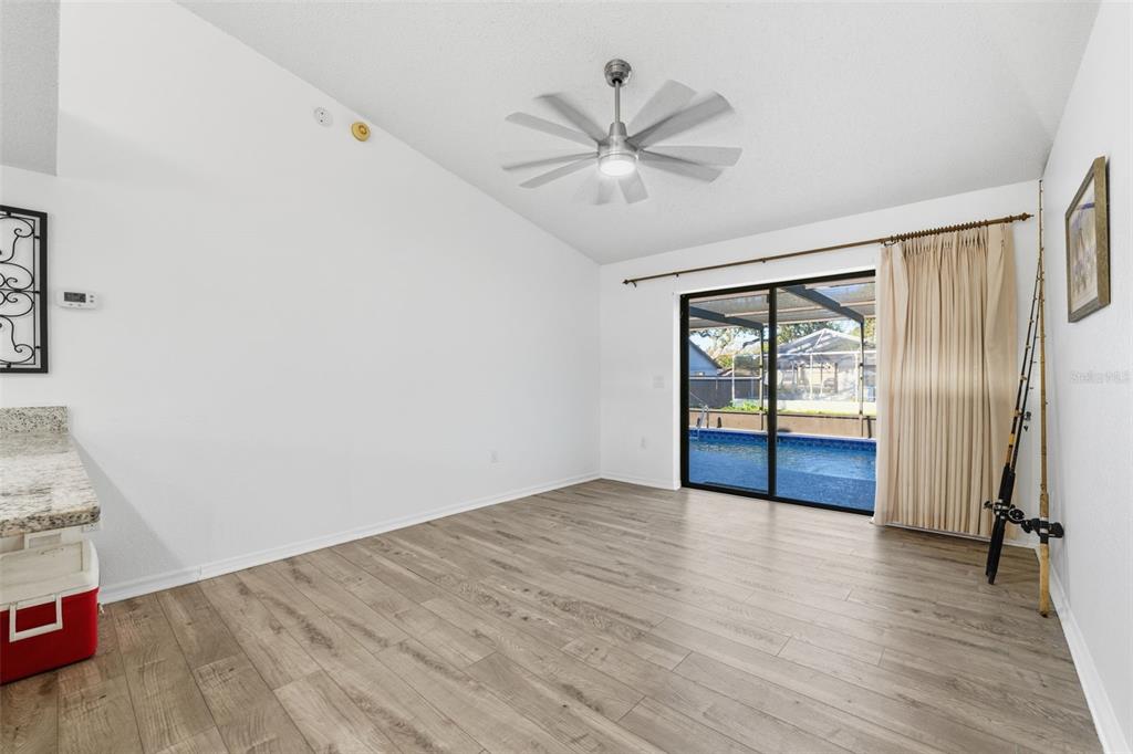 7822 Holiday Drive Spring Hill, FL 34606 - Photo 11 of 51 wooden floor in an empty room with a window