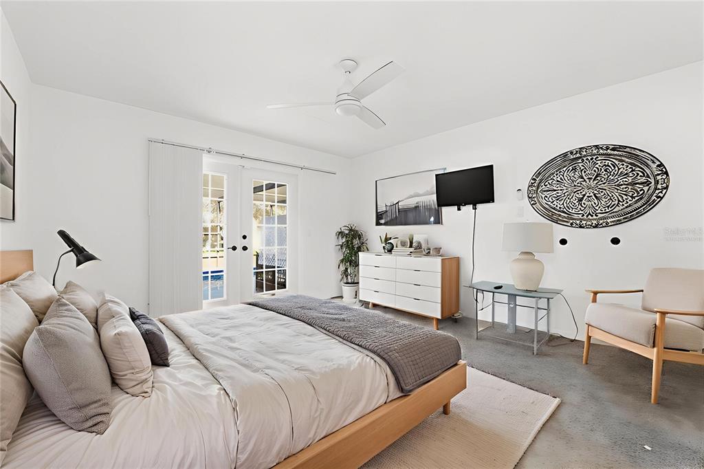 7822 Holiday Drive Spring Hill, FL 34606 - Photo 12 of 51 a bedroom with a bed a chair and potted plant on the dresser