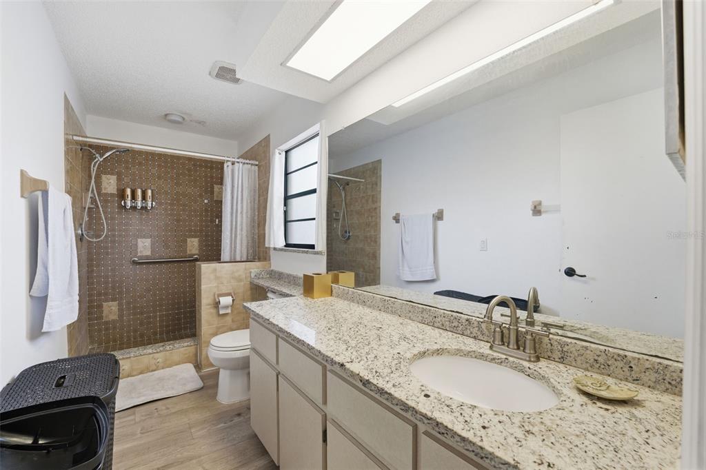 7822 Holiday Drive Spring Hill, FL 34606 - Photo 14 of 51 a bathroom with a granite countertop sink toilet and shower