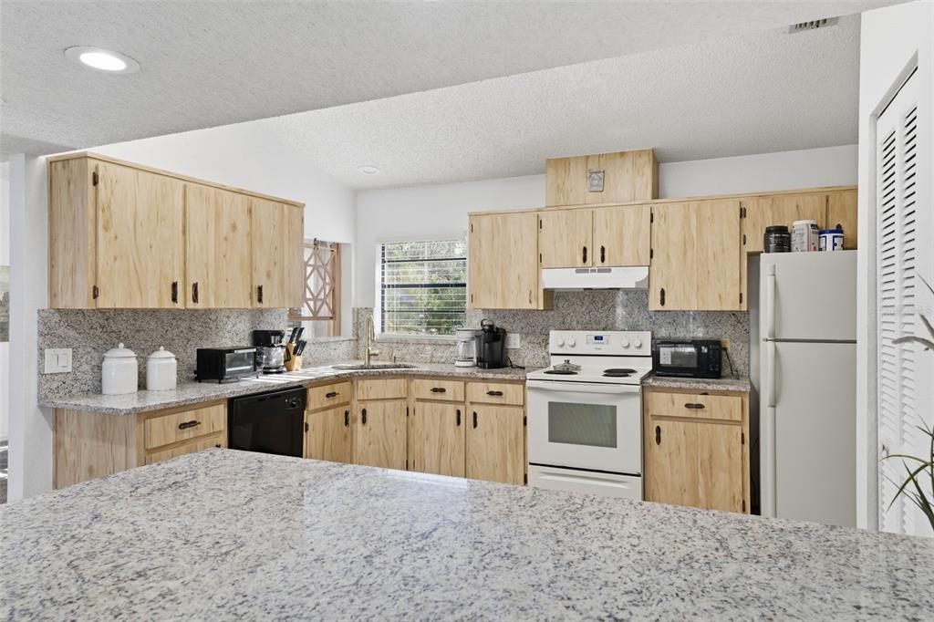 7822 Holiday Drive Spring Hill, FL 34606 - Photo 46 of 51 a kitchen with a stove sink and refrigerator