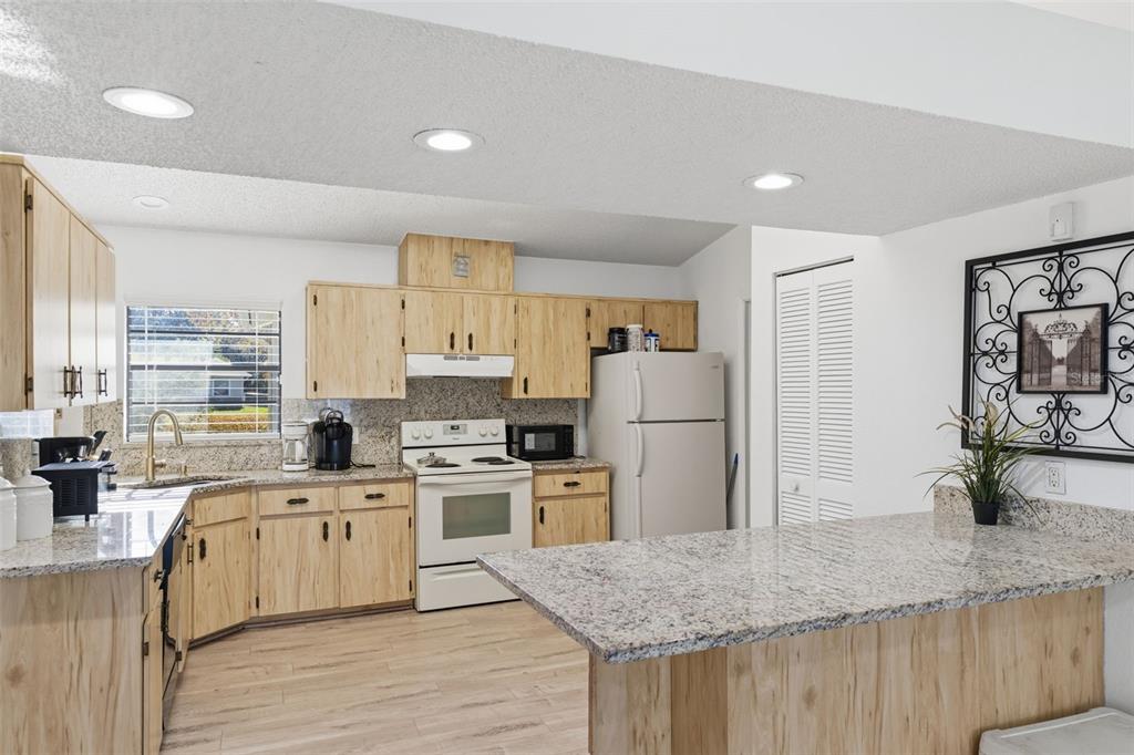 7822 Holiday Drive Spring Hill, FL 34606 - Photo 47 of 51 a large kitchen with a stove a refrigerator a sink a counter space and wooden floor