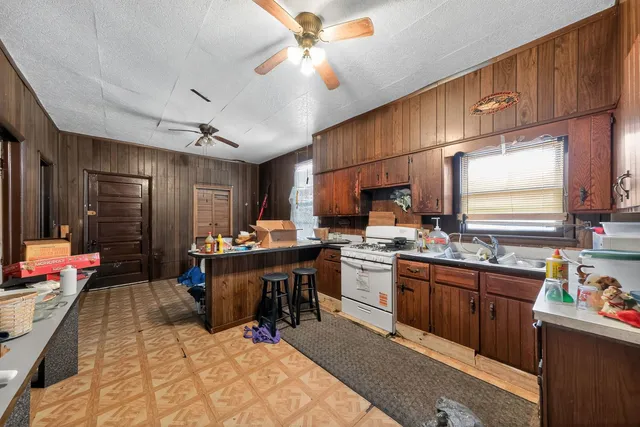 a kitchen with a sink appliances cabinets and furniture