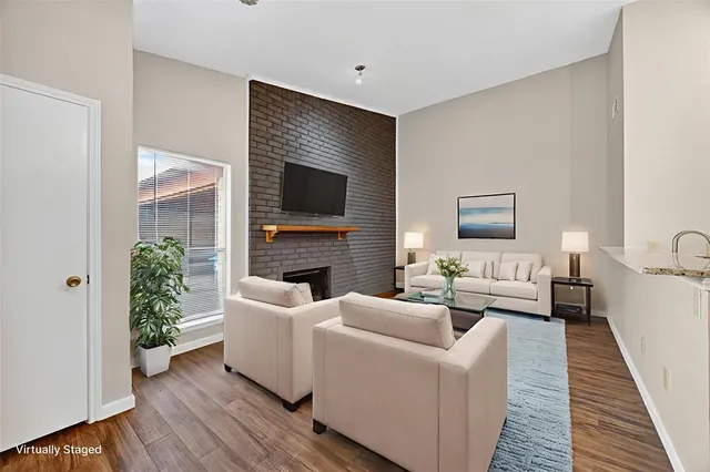 a living room with furniture a flat screen tv and a fireplace