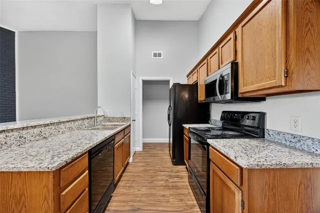 a kitchen with stainless steel appliances granite countertop a stove microwave and refrigerator