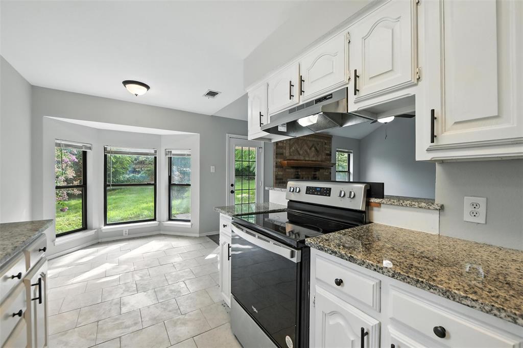 602 Valleyridge Court Decatur, TX 76234 - Photo 6 of 27 a kitchen with stainless steel appliances granite countertop a stove a sink and a white cabinets