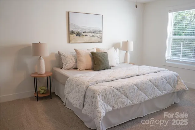a large bed sitting in a bedroom next to a window