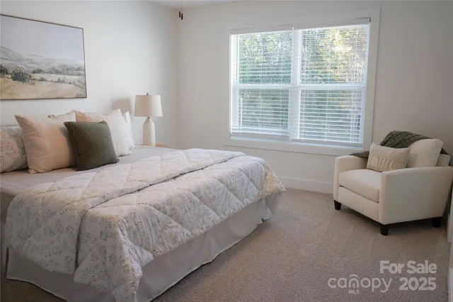 a bed sitting in a bedroom next to a window