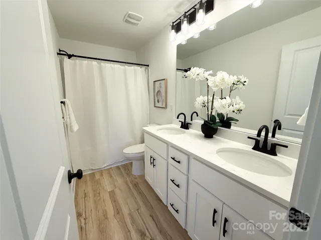 a bathroom with a double vanity sink mirror double and shower