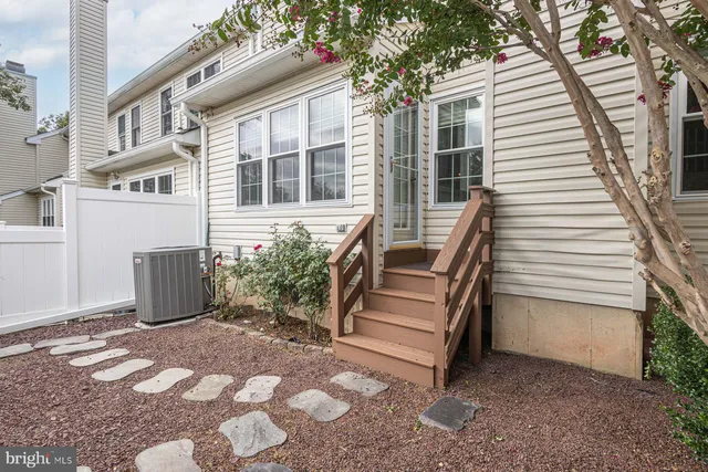 a view of a house with backyard and wooden fence