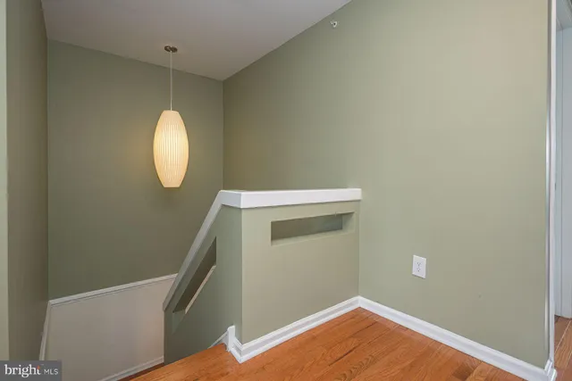 a view of a hallway with wooden floor and white walls
