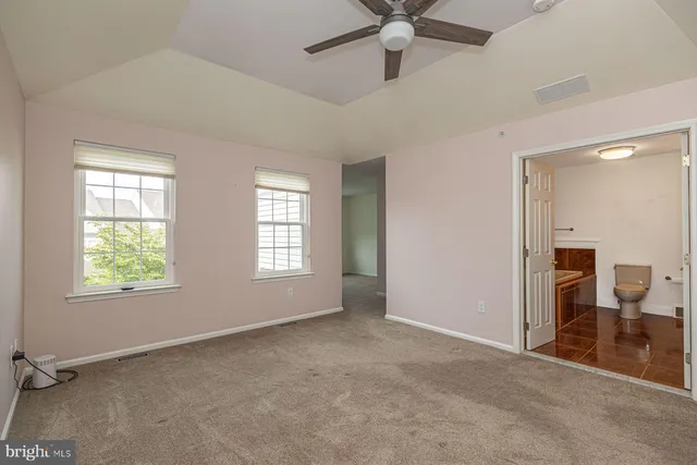 an empty room with fan and windows