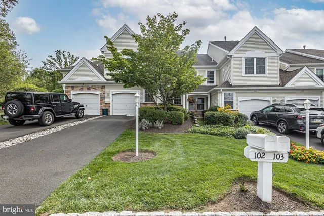 a front view of a house with a yard and trees