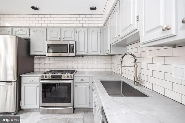 a kitchen with a stove a sink and a microwave