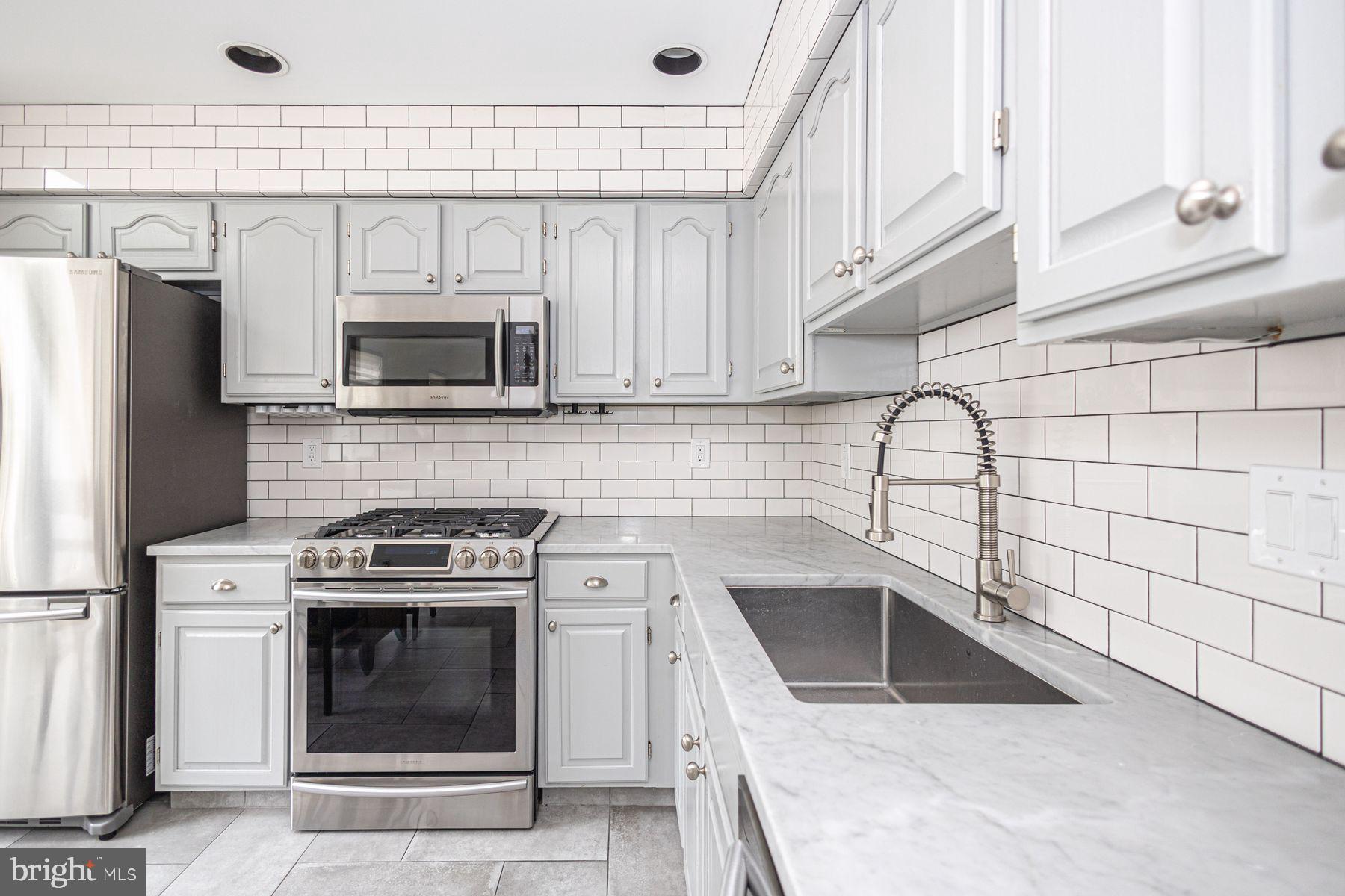 102 Waverly Lane, Unit 4 New Hope, PA 18938 - Photo 7 of 28 a kitchen with a stove a sink and a microwave