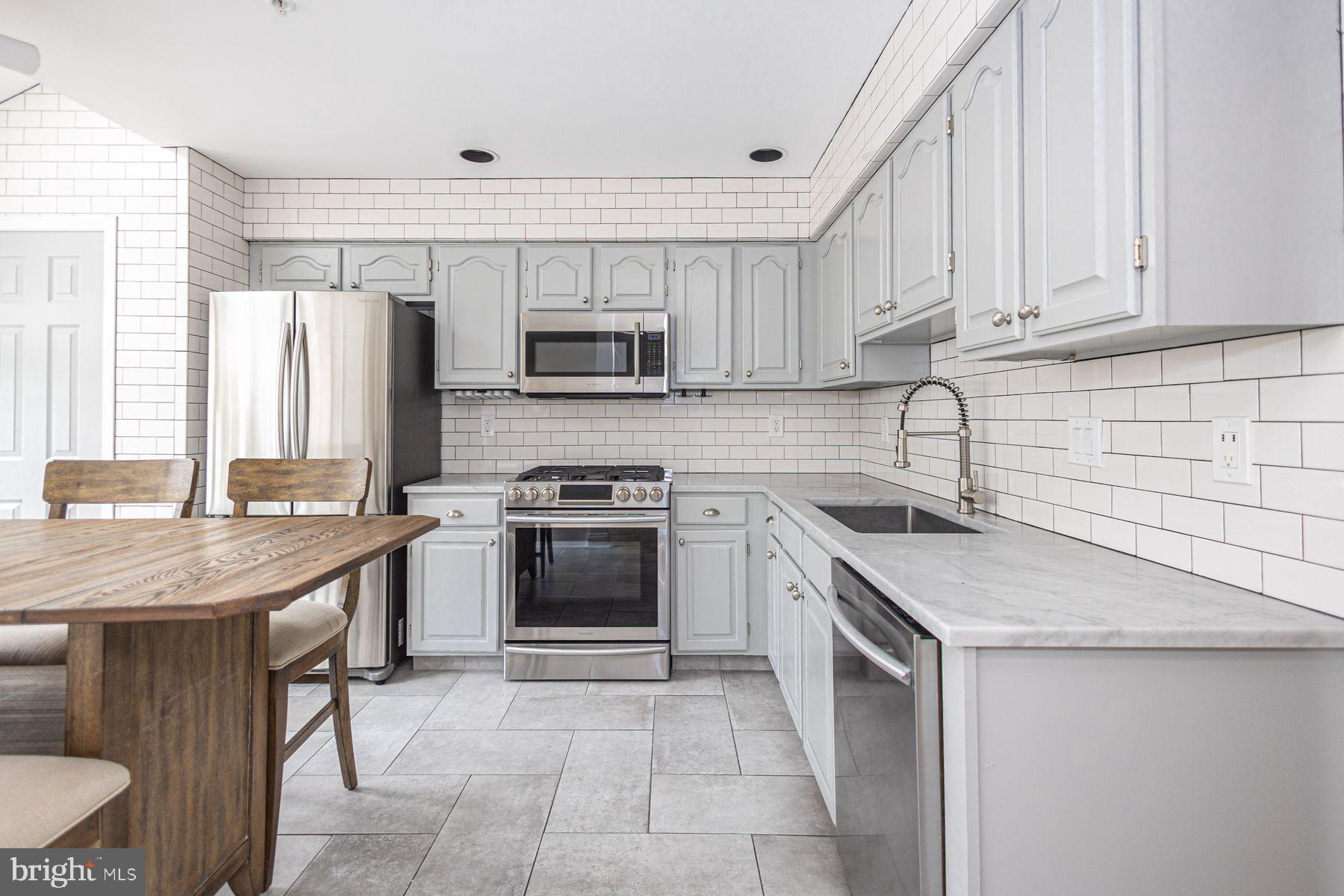 102 Waverly Lane, Unit 4 New Hope, PA 18938 - Photo 8 of 28 a kitchen with stainless steel appliances granite countertop a sink stove microwave and refrigerator