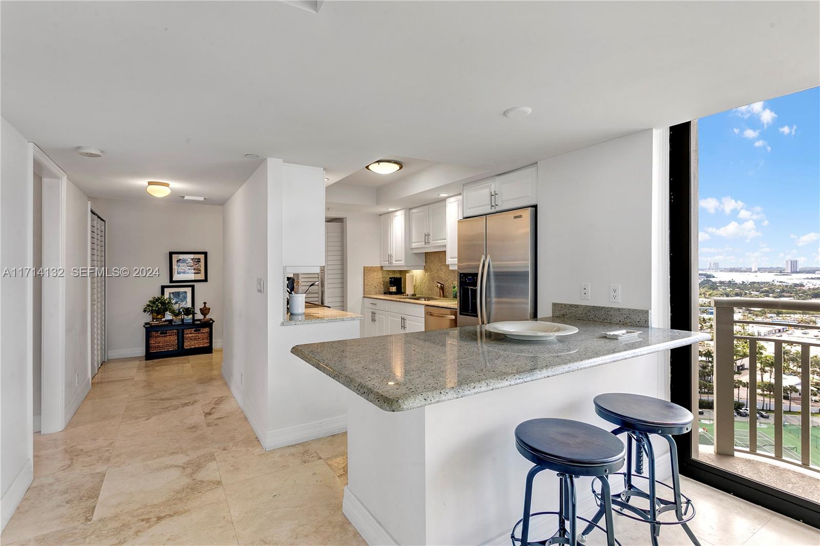 3000 North Ocean Drive, Unit 20A Riviera Beach, FL 33404 - Photo 11 of 43 a view of a kitchen counter top space a sink a refrigerator and chairs