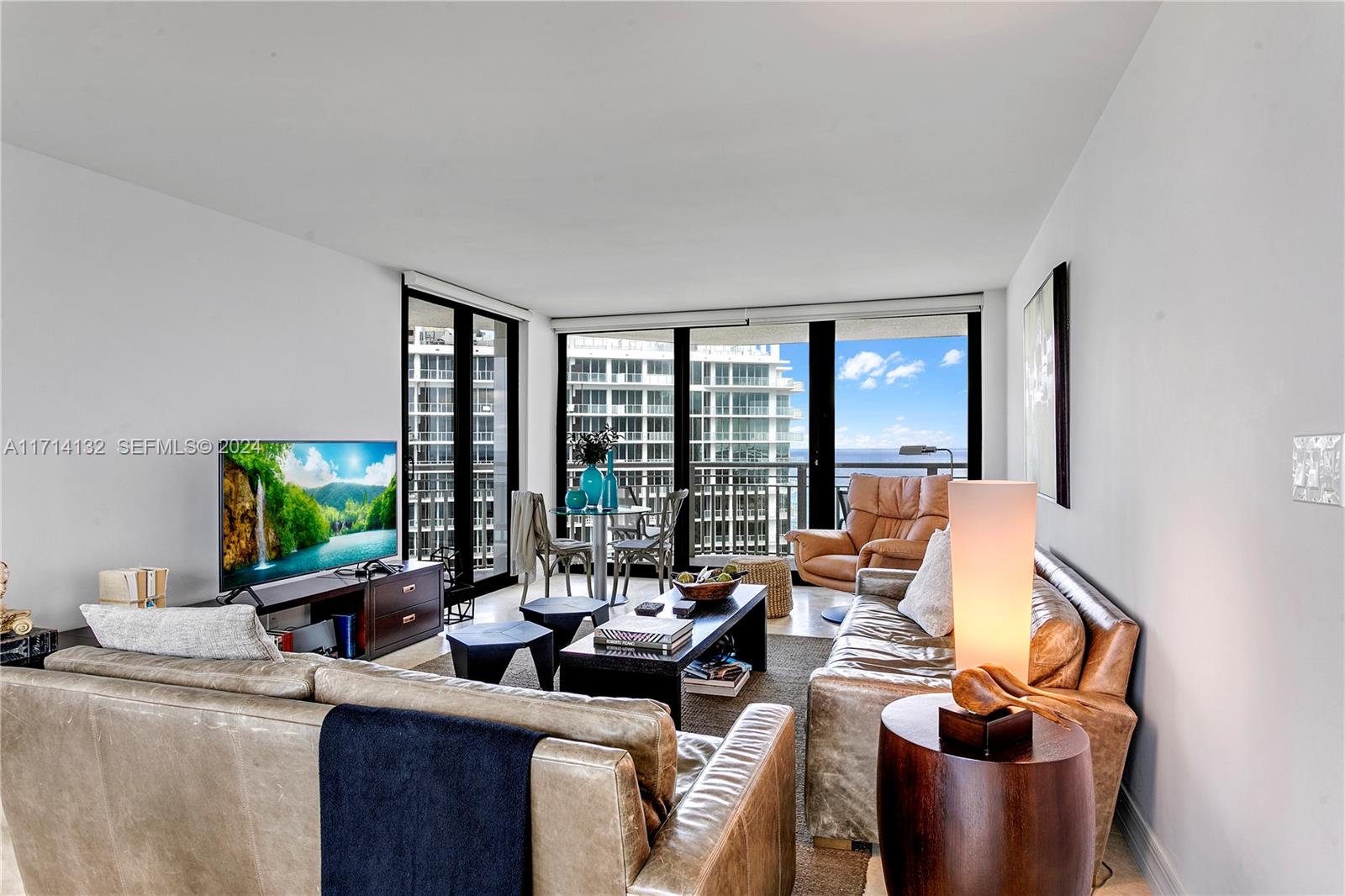 3000 North Ocean Drive, Unit 20A Riviera Beach, FL 33404 - Photo 4 of 43 a living room with furniture and a flat screen tv