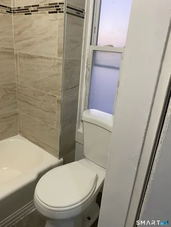 a bathroom with a toilet and a shower
