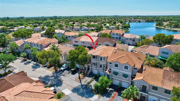 an aerial view of residential houses with outdoor space and trees