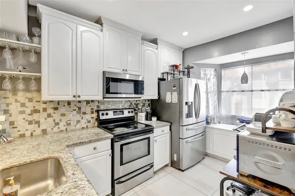 a kitchen with white cabinets and stainless steel appliances