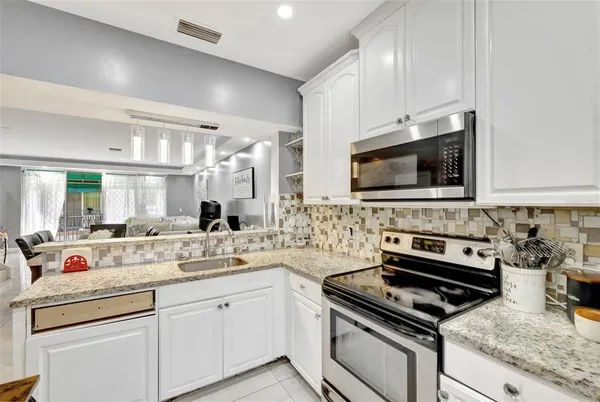 a bathroom with a granite countertop sink a mirror and shower