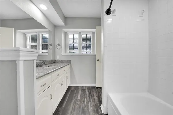 a bathroom with a granite countertop sink toilet and bathtub