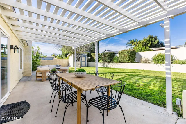 a view of a patio with a table chairs and a backyard