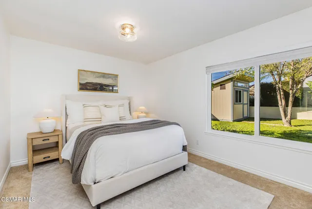a bedroom with a bed and a large window