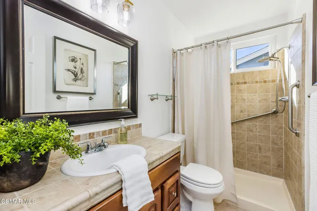 a bathroom with a toilet sink and shower curtain