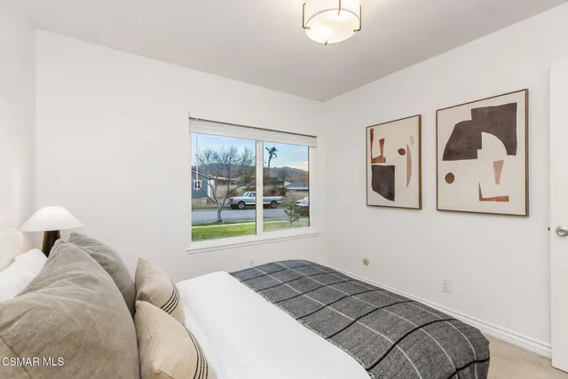 a bedroom with a bed and a painting on the wall