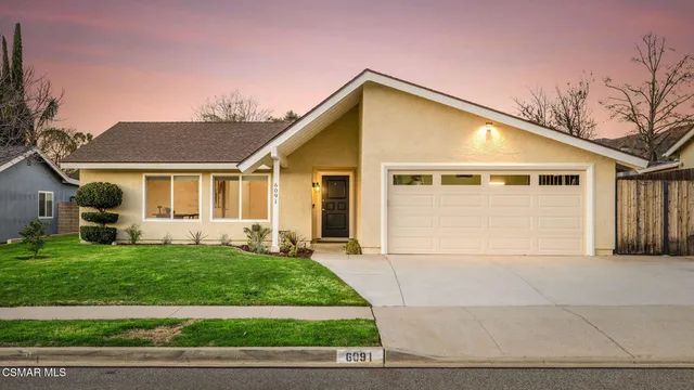 a view of a house with a yard and garage