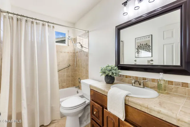 a bathroom with a granite countertop sink mirror vanity and toilet